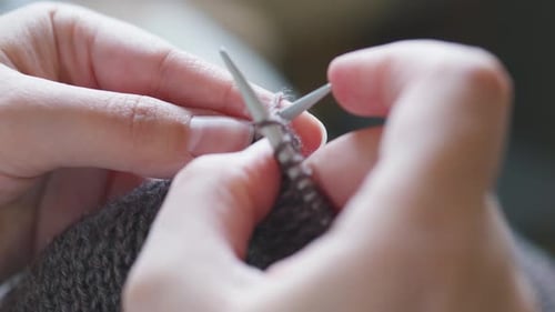 Close Up of Hands Knitting With Gray Yarn