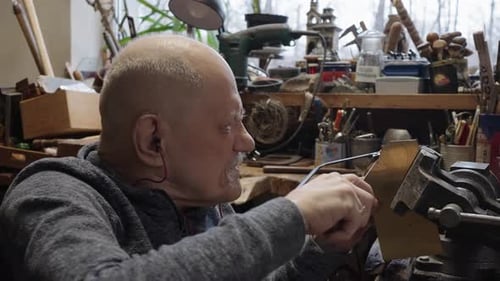 Senior Elderly Master Jeweler in Wheelchair Works in a Workshop