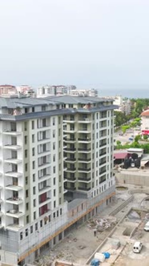 Los constructores de vídeo verticales y las máquinas pesadas trabajan juntos para acristalar balcones, terminar fachadas y