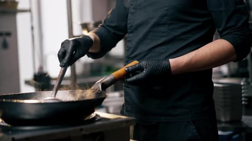 Close Up Chef Holding Frying Pan with Readymade Noodles Against the Backdrop of Sunset
