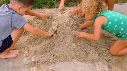 Children Playing Together with Sand Outdoors on Sunny Day