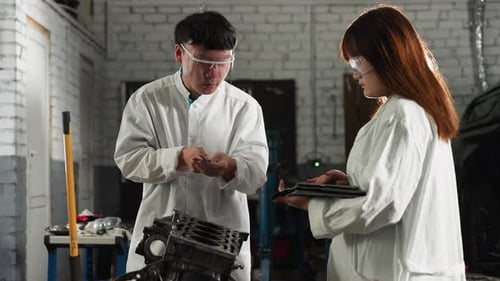 Lab Technicians Measuring Engine Component with Vernier Caliper in Automotive Workshop
