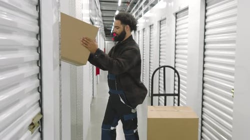 Jeune homme afro-américain déchargeant des boîtes en carton dans un stockage climatisé
