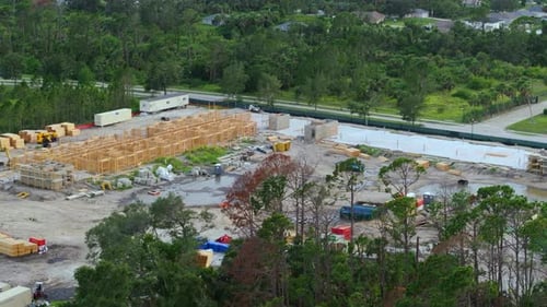 Vista desde arriba del marco inacabado de los condominios de apartamentos con vigas de madera en el techo en construcción