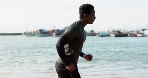 Running, fitness and black man on beach for exercise, marathon training and cardio workout outdoors