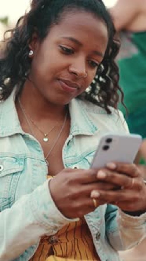 Closeup of young woman using a mobile phone in an urban city background