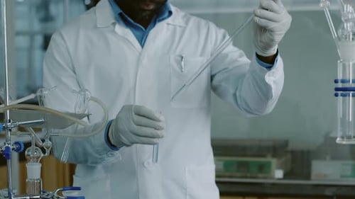 Male Lab Technician Filling Glass Tubes with Solution for Tests