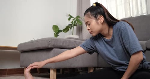 Woman Doing Seated Hamstring Stretch at Home