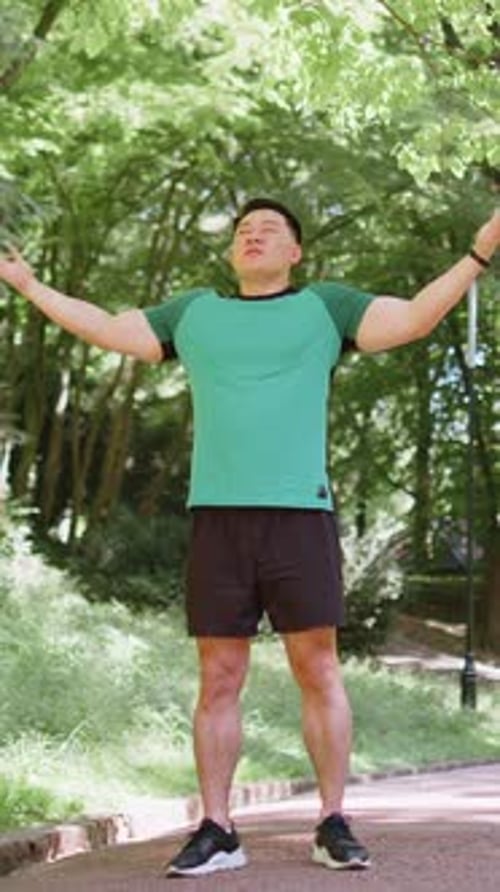 Man Standing in Park Breathing Deeply