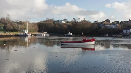 An ascending aerial shot revealing boats anchored in the River Brandon on a quiet fall morning in Ki