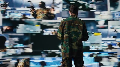 Man With Tablet Stands Before Military Images