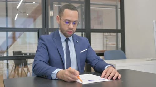 Man in Suit Working on Documents in Office