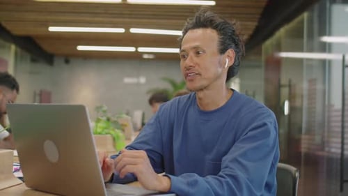 Man Talking on Laptop in Modern Office