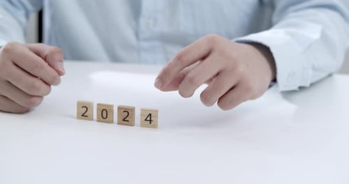 Young office worker replacing the number 4 with 5 to represent the shift from 2024 to 2025.