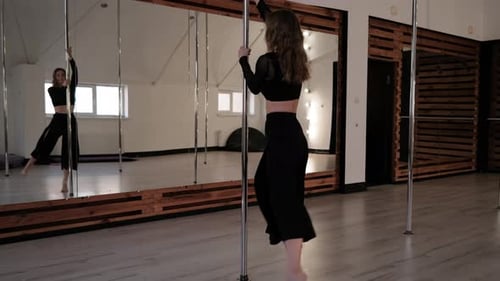 Woman Performing Pole Dance in Bright Studio