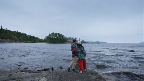 Loving Couple Standing On Coast Of Beautiful Lake Boyfriend Hugging His Girlfriend Back View