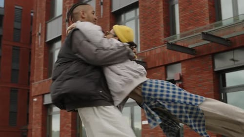 Man Lifts and Spins Young Woman in Embrace