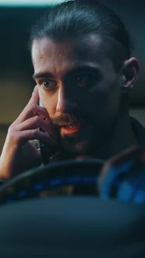 Man Talking on Phone in Car at Night