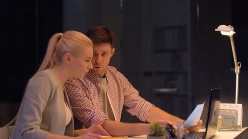 Colleagues Reviewing Documents on Laptop in an Office