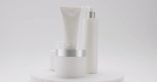White Bottles and Tubes Rotate for Cosmetics on White Background in Studio