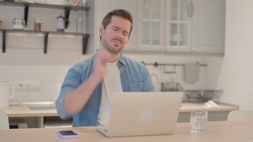 Man With Neck Pain Using Laptop at Home