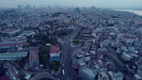 Drone flight over the city of Istanbul with traffic on streets between buildings with a cloudy sky