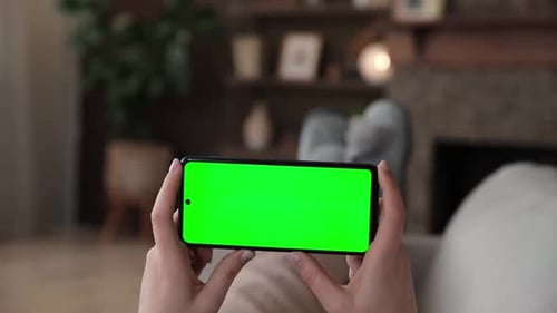 Point of View of Woman Lying on Couch Using Horizontal Smartphone with Chroma Key Green Screen