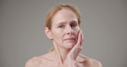 Adult Woman Touches Face in Beauty Portrait