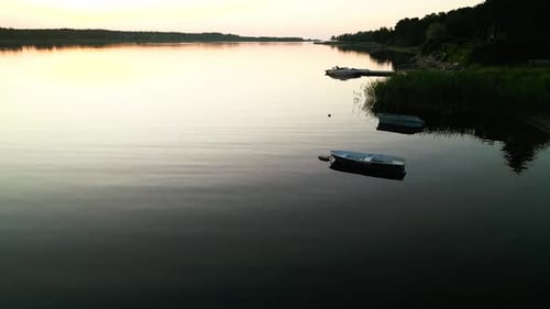 A Tranquil Aerial View of a Serene River with Boats at Sunset Capturing the Peaceful Nature of the