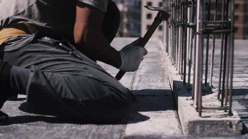 Construction Worker Hammering Rebar on a Rooftop