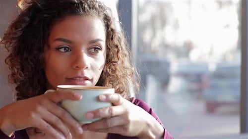 Woman Enjoys Coffee in a Cafe