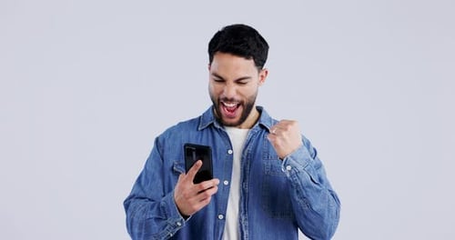Man, excited and phone in studio for winning, celebrate success and mobile notification of bonus