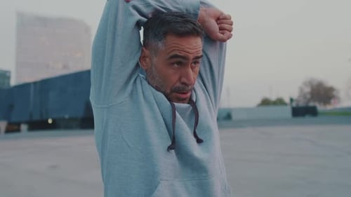 Man Stretching Arms in Urban Setting