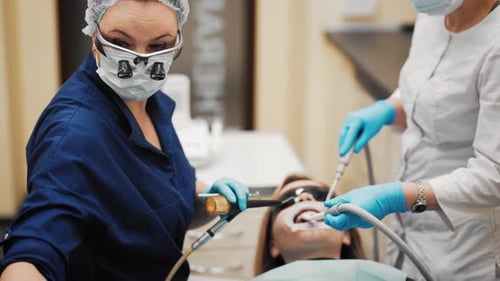 Curing Teeth in Stomatological Clinic Professional Stomatologists and Patient Medium Shot Inside