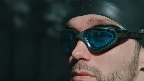 Portrait of Ambitious Male Swimmer Putting on Goggles before Competition