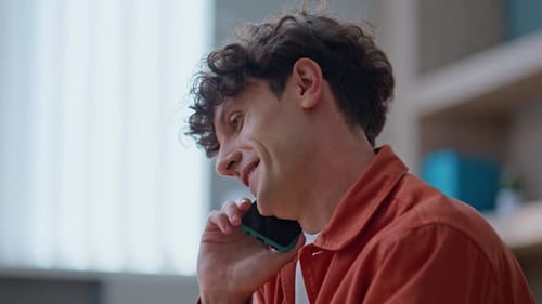 Young Adult Working on Laptop Talking on Phone