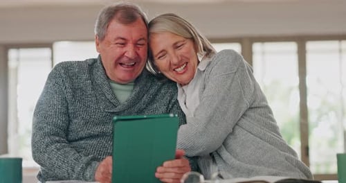 Senior Couple Laughing at Tablet Screen at Home