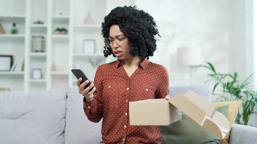 Confused Woman with Phone and Open Delivery Box