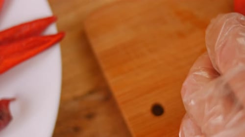 Gloved Hand Slices Fresh Red Chili Pepper