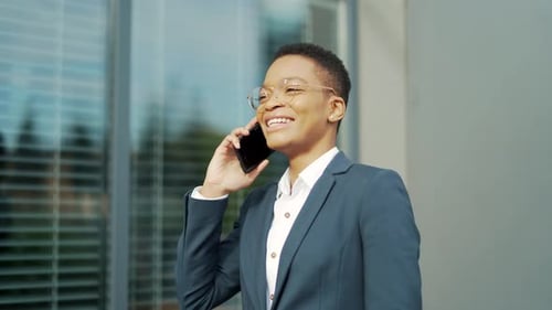 Smiling Businesswoman Talking on Phone Outside Office