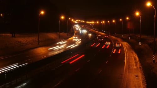 Timelapse de carros se movendo ao longo de uma rodovia noturna de inverno, tráfego intenso noturno