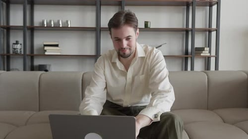 Concentrated Young Business Man Indoors in Office Using Laptop Computer