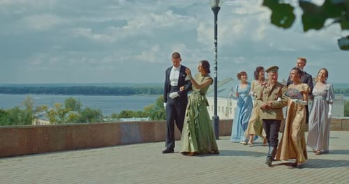 Beautiful Men and Women in Historical Costumes Walk Along the Embankment of the City They are Happy
