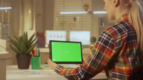 Back View of a Young Woman is Holding a Green Screen Digital Tablet