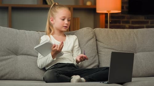 Child Studies Online While Sitting on Couch