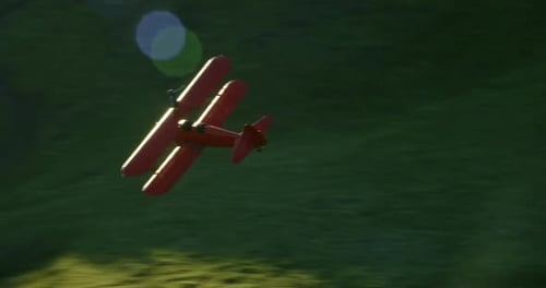 Antique Biplane Wing Walker Soaring Over Green Hills