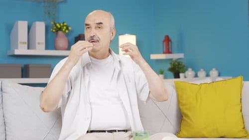 Man Fanning Himself on a Couch