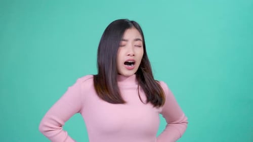 Woman Yawns Covering Mouth on Light Cyan Background