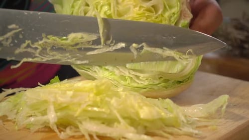 Chopping Fresh Crisp Iceberg Lettuce on Cutting Board
