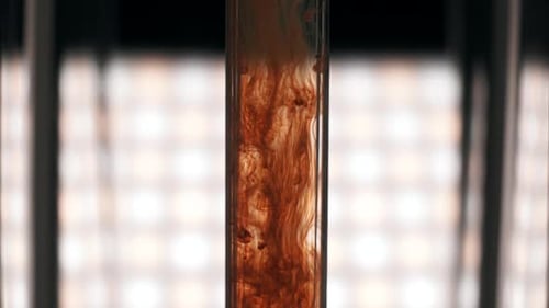 Red-brown ink drop in water, drop color mixture falls on water. Slow motion